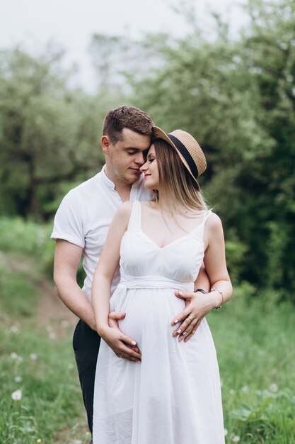 The lovely couple in love embracing and standing on the grass