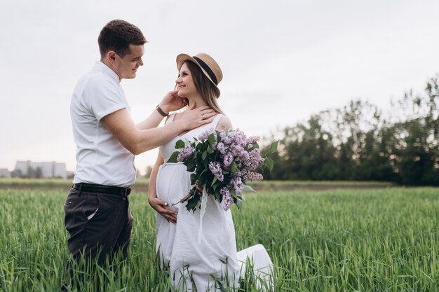 The lovely couple in love looking at each other and keeping bouquet