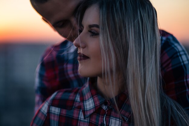 The lovely couple in love standing on the roof