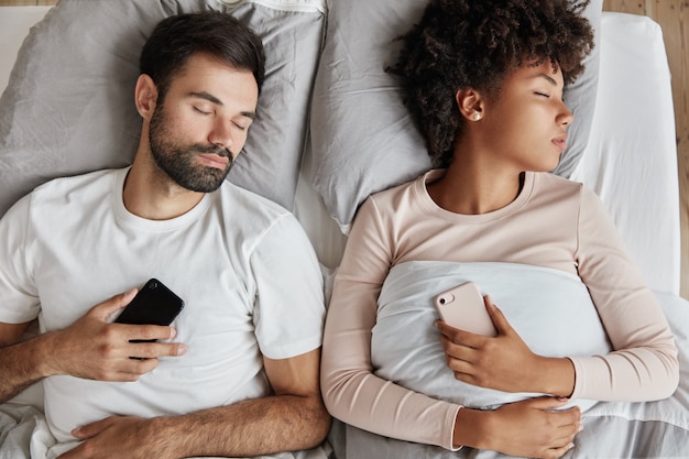 Coppia adorabile che dorme nel letto comodo