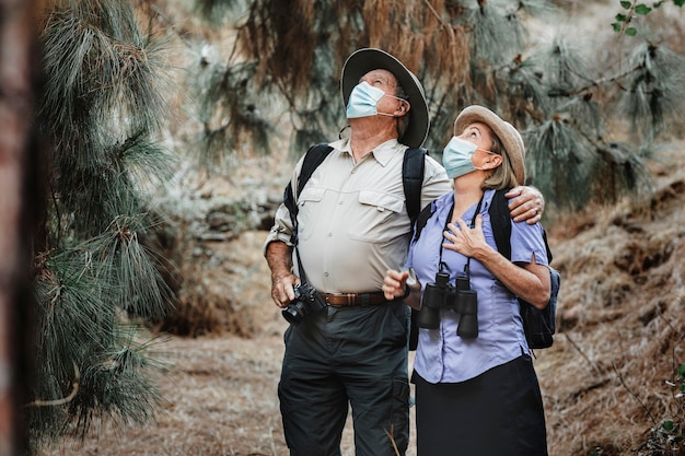 Foto gratuita una coppia adorabile viaggia indossando una maschera per proteggersi dal covid-19