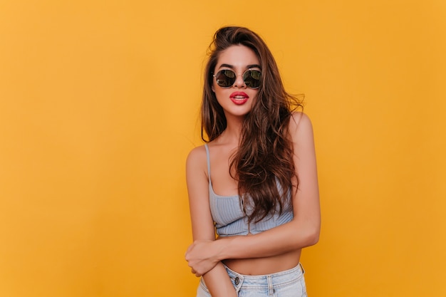 Free photo lovely dark-haired woman in trendy sunglasses playfully posing