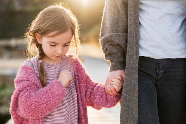 Lovely daughter and mother holding hands