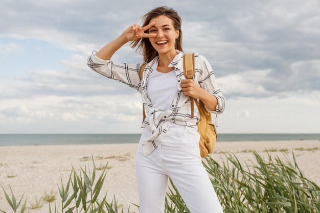 休日を楽しんでいるバックパックで素敵なデボネア旅行ブルネットの女性。