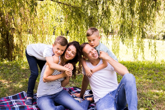 Free photo lovely family playing on picnic blanket