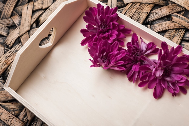 Lovely flowers concept with wooden tray