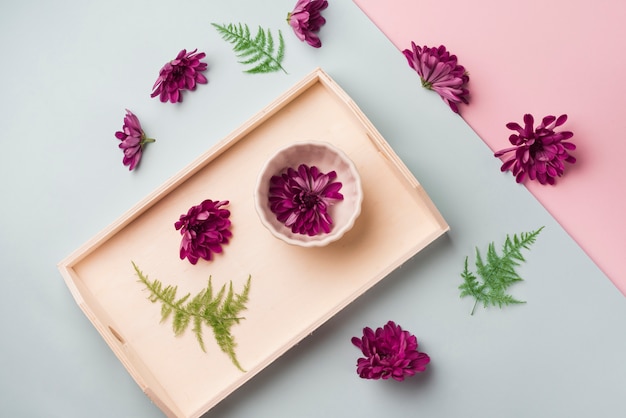 Free photo lovely flowers concept with wooden tray