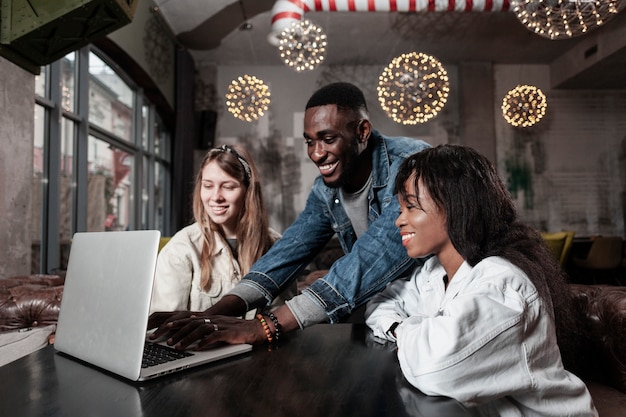 Lovely friends looking at laptop indoors