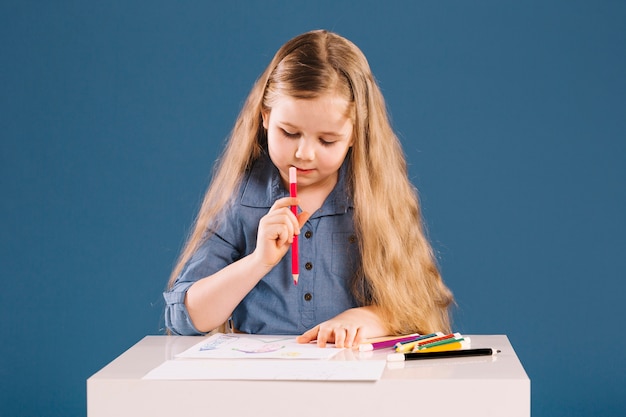 Lovely girl drawing at table