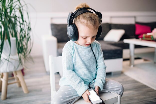 Lovely girl listening to music on chair