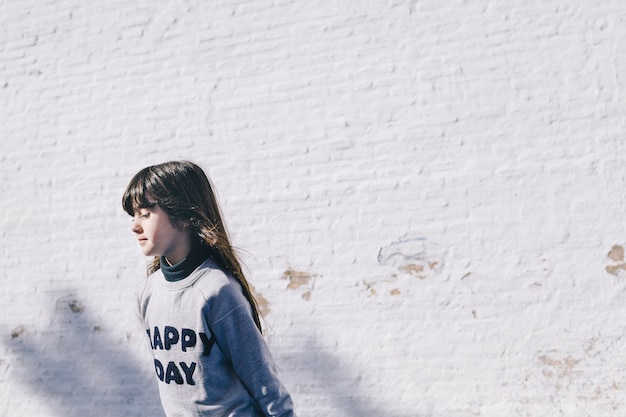 Lovely girl near white wall