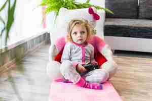 Free photo lovely girl playing video game in armchair