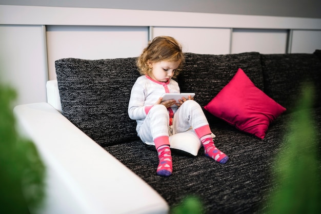 Free photo lovely girl using tablet on sofa