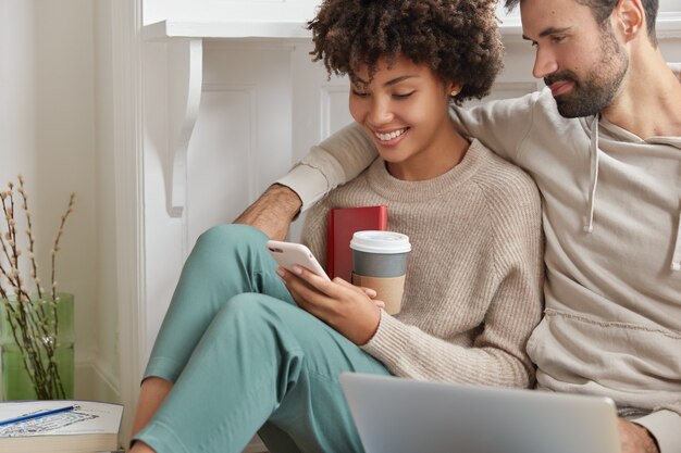 Lovely girlfriend and boyfriend cuddle while sit together