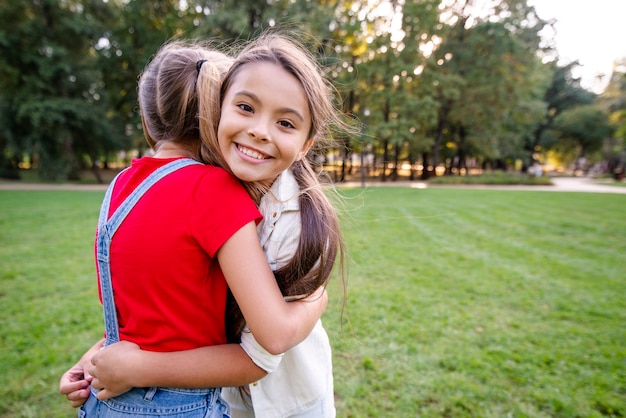 Lovely girls hugging each other outdoors