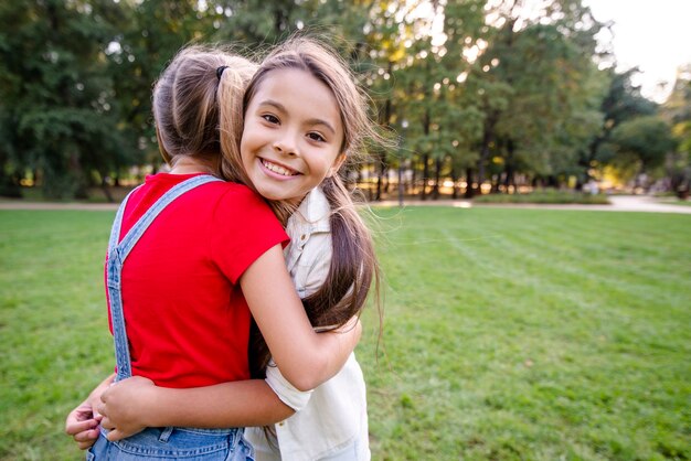 Lovely girls hugging each other outdoors