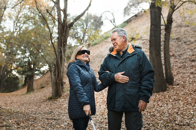 Lovely grandpa taking his blind wife for a walk