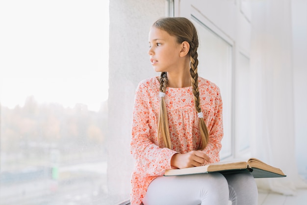 Foto gratuita bella ragazza felice in posa con un libro