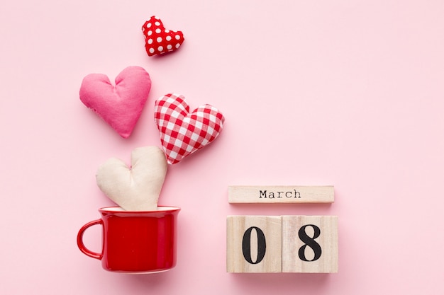 Free photo lovely hearts on pink background with 8 march lettering