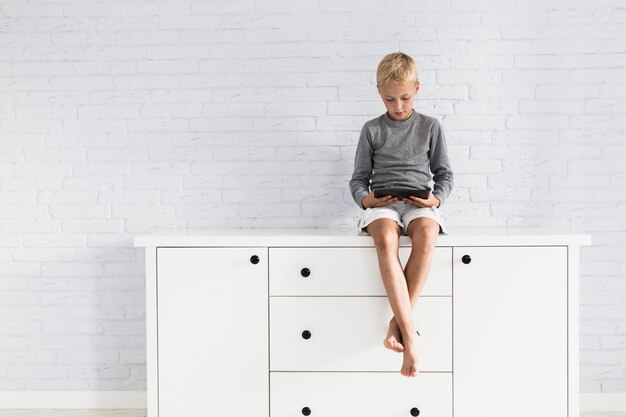 Lovely little boy having fun with tablet