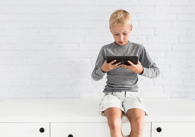 Lovely little boy having fun with tablet