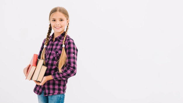 Lovely little girl holding books