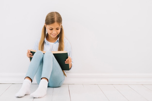 Lovely little girl reading a book