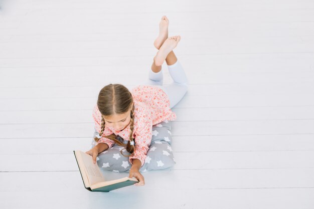 Lovely little girl reading a book