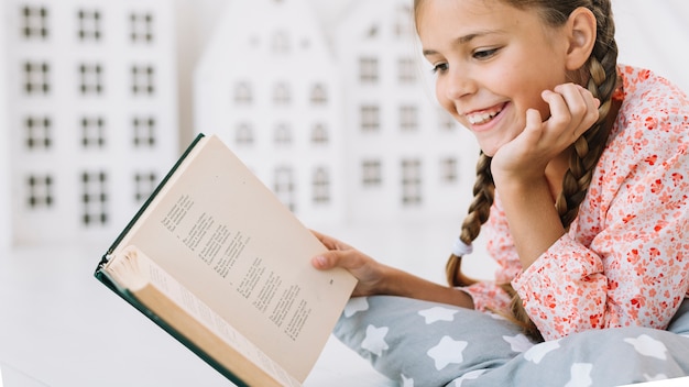 Free photo lovely little girl reading a book