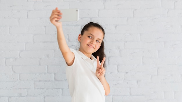 Foto gratuita bambina adorabile che prende un selfie