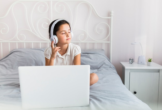 Foto gratuita bambina adorabile che utilizza il suo computer portatile