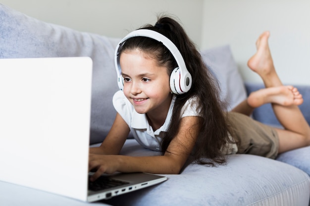 Free photo lovely little girls using her laptop