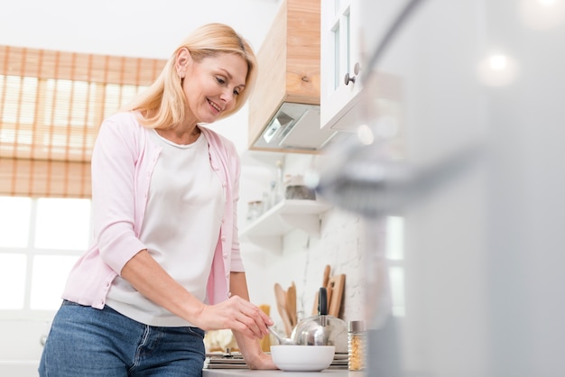 Lovely mature woman serving breakfast at home