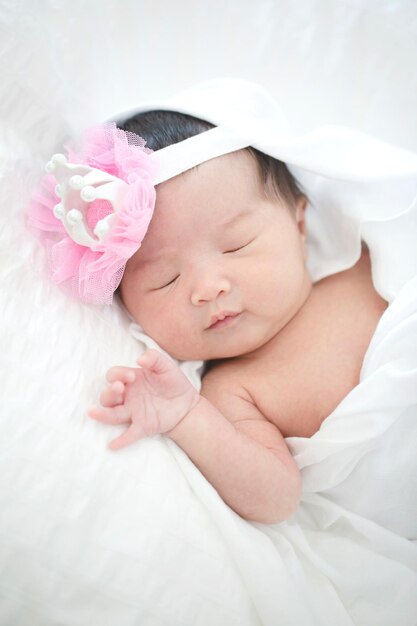 Lovely newborn Asian baby sleeping on furry cloth