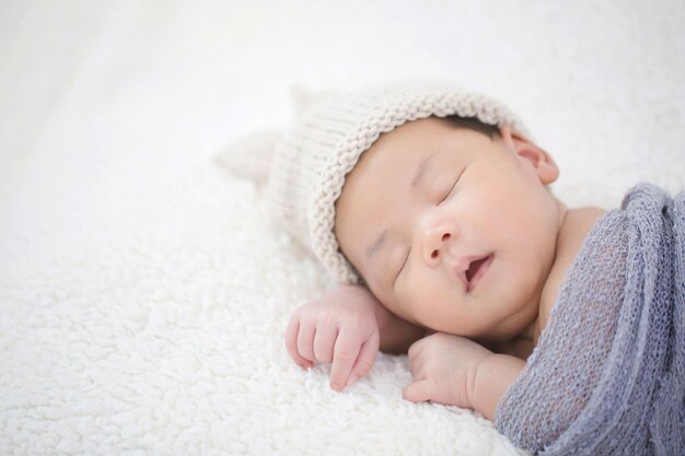 Lovely newborn Asian baby sleeping on furry cloth