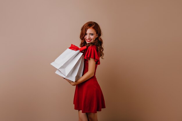 쇼핑 후 포즈를 취하는 사랑스러운 red-haired 소녀. 매력적인 여성 쇼핑 중독.