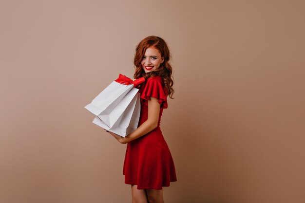Lovely red-haired girl posing after shopping.  charming female shopaholic.