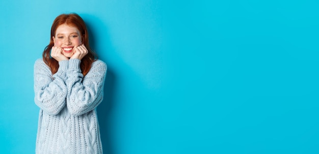 Adolescente adorabile della testarossa che sembra sognare ad occhi aperti fissando con ammirazione una simpatia alla macchina fotografica in piedi