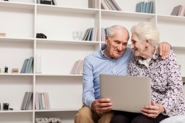 Прекрасная пара старших, держа ноутбук