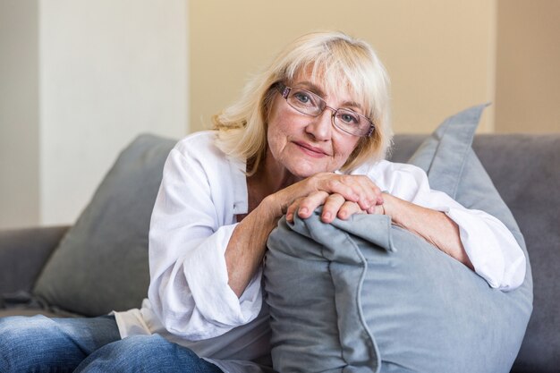 枕にもたれて眼鏡で素敵な年配の女性
