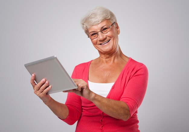 현대 디지털 태블릿을 사용 하여 사랑스러운 노인 여성