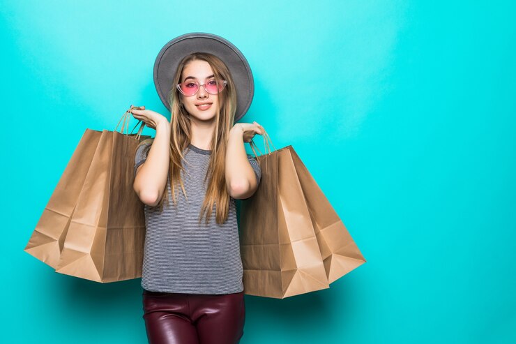Free Photo lovely shopping woman smiling and wearing a hat isolated over green background