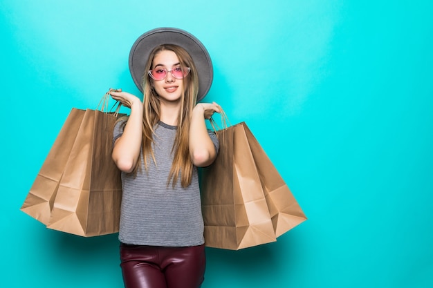 Lovely shopping woman smiling and wearing a hat isolated over green background