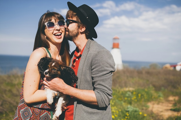 Free photo lovely smiling young stylish hipster couple in love walking with dog in countryside