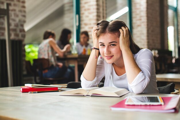 Lovely teen with books posing at camera