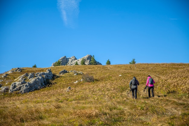 Прекрасная туристическая пара, поднимающаяся на словенские скалистые горы под голубым небом
