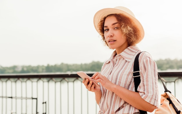 Bella donna che controlla il suo telefono all'aperto