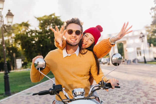 Lovely woman in cute red hat waving hands enjoying extreme date with boyfriend