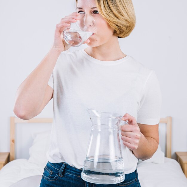 ベッドで素敵な女性の飲み水