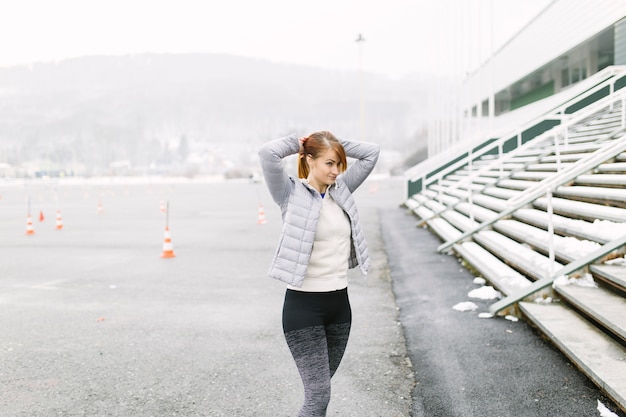 Lovely woman making ponytail during training